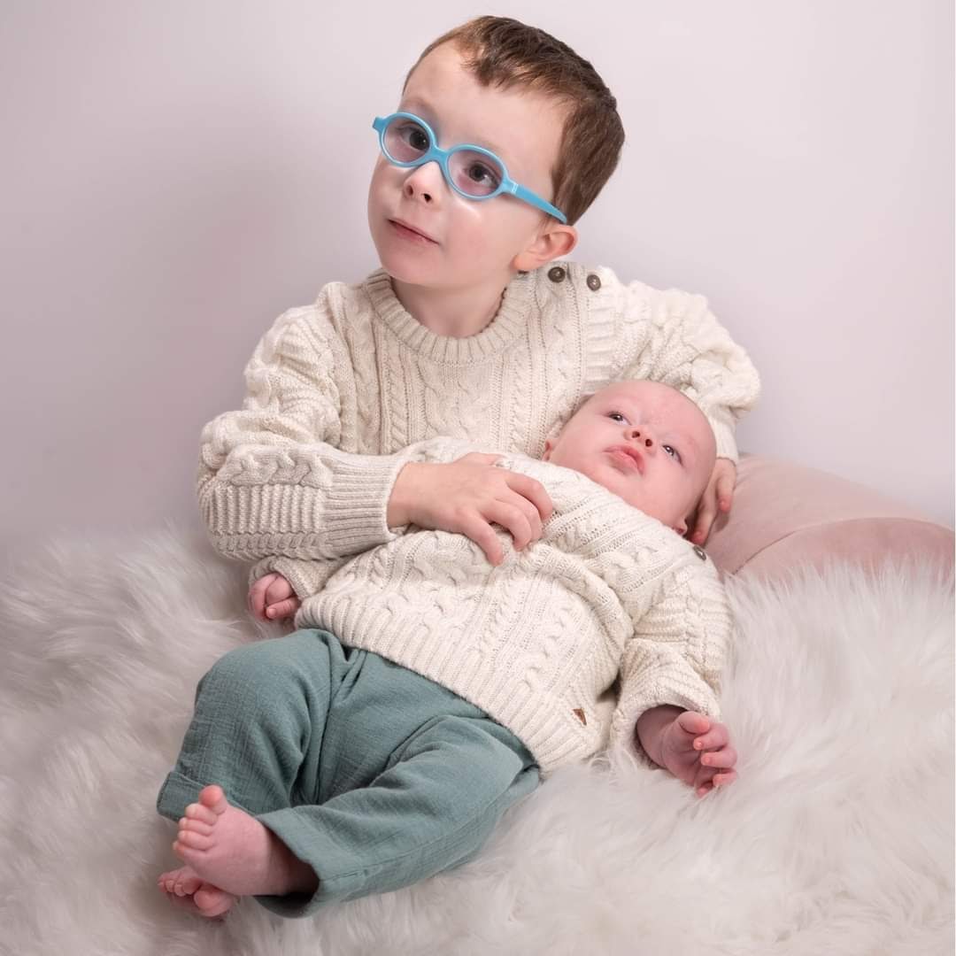 2 little brothers cuddle in a family studio shoot